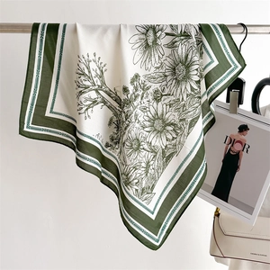 Detail of vintage floral silk scarf hanging on metal rack with a white background
