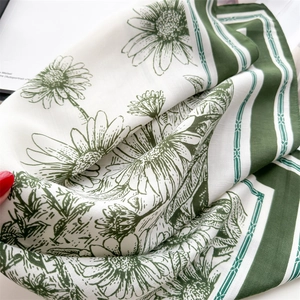 Detail of vintage floral silk scarf showing soft folds and green daisy prints