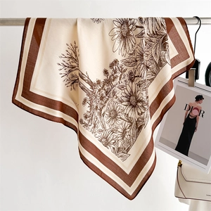 Detail of vintage floral silk scarf with sunflower print and striped border draped on a rack