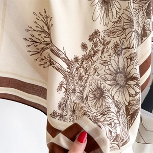 Detail of vintage floral silk scarf featuring intricate botanical prints and a striped border