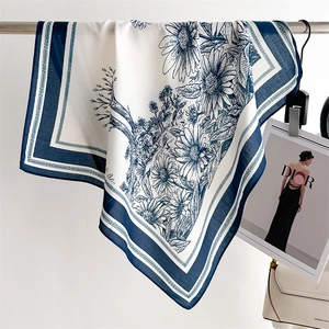 Detail of vintage floral silk scarf featuring blue daisy prints and elegant geometric borders