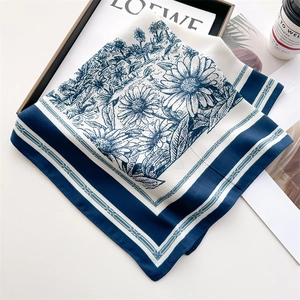 Detail of premium satin square scarf with elegant floral prints and a silky texture