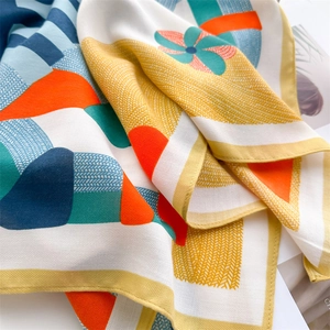 Detail of orange pony print silk scarf showing herringbone texture and hand-rolled edges