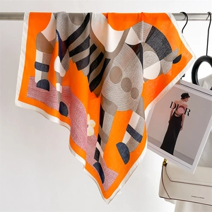 Detailed view of an orange silk scarf with abstract horse print and rolled edges
