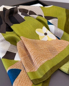Macro detail showing green scarf with herringbone weave and delicate floral prints