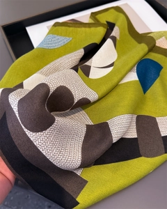 Close-up of silk-like scarf showing modern geometric patterns and herringbone weave texture