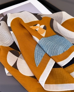 Detailed macro view of an orange abstract fox print silk scarf with herringbone texture