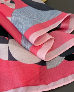 Close-up of pink herringbone weave fabric detail on high-quality printed silk scarf