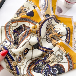 Detail of vintage carriage chain print on silk scarf with elegant lifestyle props