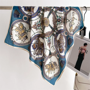 Detailed view of horse and chain print on silky scarf with elegant fringe elements