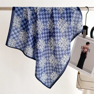 Detail of elegant blue and white houndstooth silk scarf hanging on a metal rod