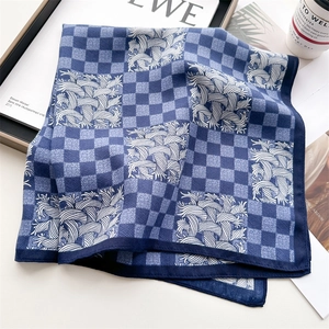 Detail of blue and white luxury silk scarf with geometric pattern and roll hem