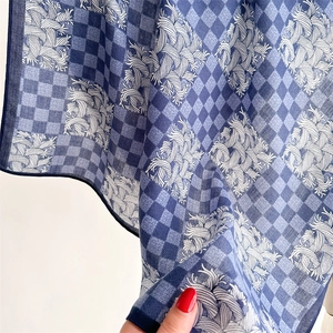 Detail of blue houndstooth silk scarf showing lightweight breathable fabric texture