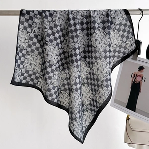 Detail of elegant black and white silk scarf with houndstooth and vortex patterns
