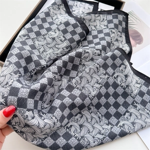 Macro detail of houndstooth silk scarf with swirl patterns and fine rolled edges