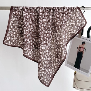Detail of coffee brown floral silk scarf with delicate white blossoms and soft drape