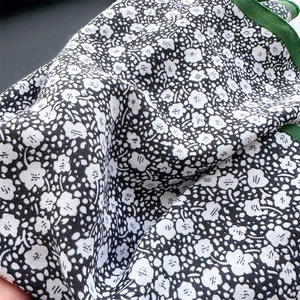 Detail of floral silk scarf showing fine print and handmade rolled green edges