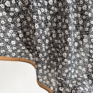 Macro shot of floral pattern fabric with elegant brown hem and soft draped texture