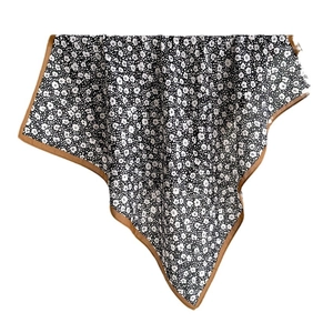 Black and white floral print silk scarf with brown border in a draped elegant style
