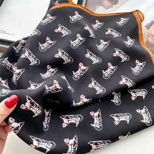 Detail of a black silk scarf with horse carriage pattern and orange hand-rolled edges