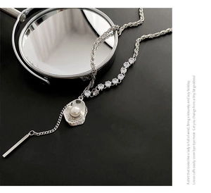 Vue macro d'un collier de perles minimaliste avec zircone et barre métallique en argent