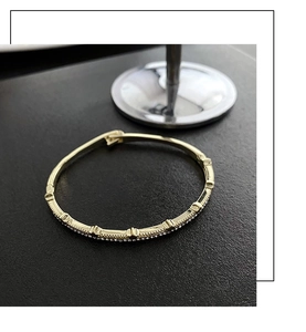 Macro shot of a gold adjustable bracelet featuring geometric patterns and pavé zircons