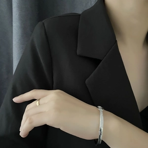Bracelet argenté brillant motif léopard et bague dorée sur mannequin en costume noir