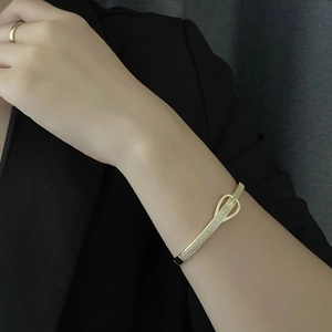 Bracelet jononc doré chic avec boucle en zircone cubique porté sur le poignet