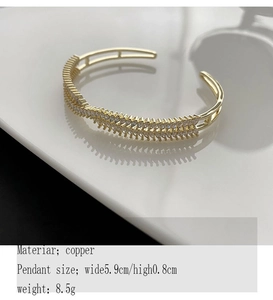 Detailed view of a gold-plated copper bangle with zircon crystals measuring 5.9cm by 0.8cm