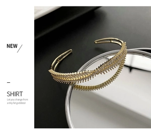 Detail of gold open cuff bracelet with double rows of marquise-cut sparkling zircons