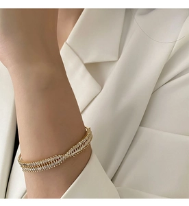 Close-up of luxury gold-plated bangle featuring double rows of marquise-cut zircons