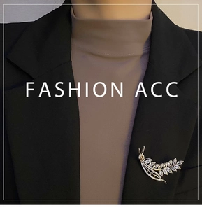 Detail view of a golden wheat zircon brooch pinned on a black blazer lapel