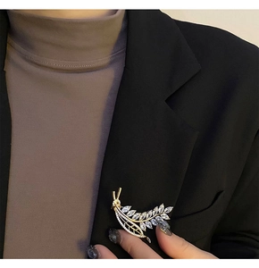 Elegant gold wheat brooch with zircon crystals pinned on a black suit lapel