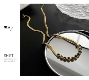 Macro detail of gold snake chain necklace featuring inlaid round black zircon stones