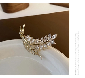 Detailed close-up of golden wheat brooch with sparkling marquise-cut zircon stones
