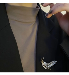 Close-up of a luxury wheat ear zircon brooch pinned on a black professional blazer