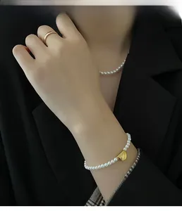 Close-up of pearl jewelry set with necklace and bracelet on model wearing black suit