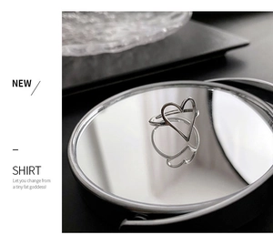 Détail macro de la bague coeur en argent poli avec reflet sur une surface miroir