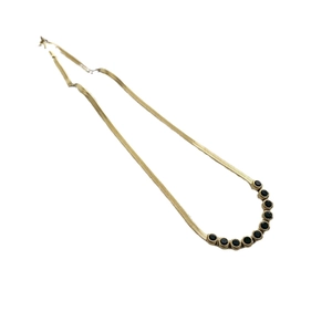 Golden herringbone chain necklace with circular black gemstones in a curved arrangement