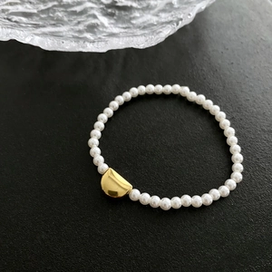 Elegant pearl and gold crescent moon titanium steel bracelet on black textured background
