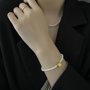 Elegant pearl jewelry set with gold heart charms on titanium steel bracelet and necklace