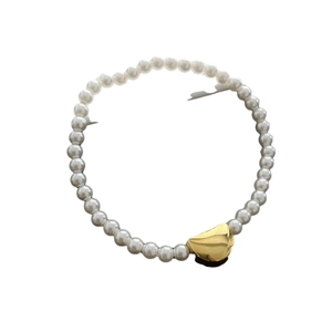 Minimalist pearl bracelet with gold stainless steel bead on a clean white background