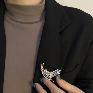 Elegant gold wheat ear brooch with sparkling zircon crystals on a black blazer jacket