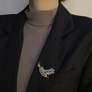 Elegant silver wheat ear leaf brooch with zircon crystals on a black suit lapel