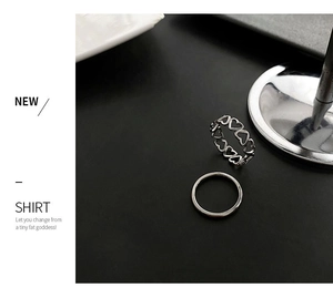 Detail of silver heart rings set featuring a simple band and hollow heart band design