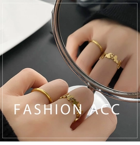 Macro shot of gold butterfly rings set with artistic cut-out details and mirror reflection