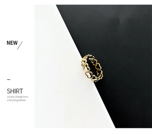 Detailed view of gold minimalist ring featuring continuous hollow heart pattern design