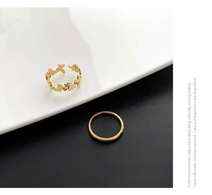 Detail view of butterfly cutout open ring and minimalist gold band ring set