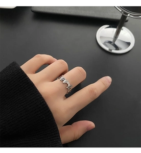 Close-up of polished titanium steel butterfly ring with cutout design on model's finger
