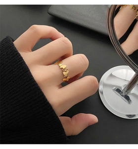 Close-up of a minimalist golden butterfly ring worn on a finger with stylish metallic shine